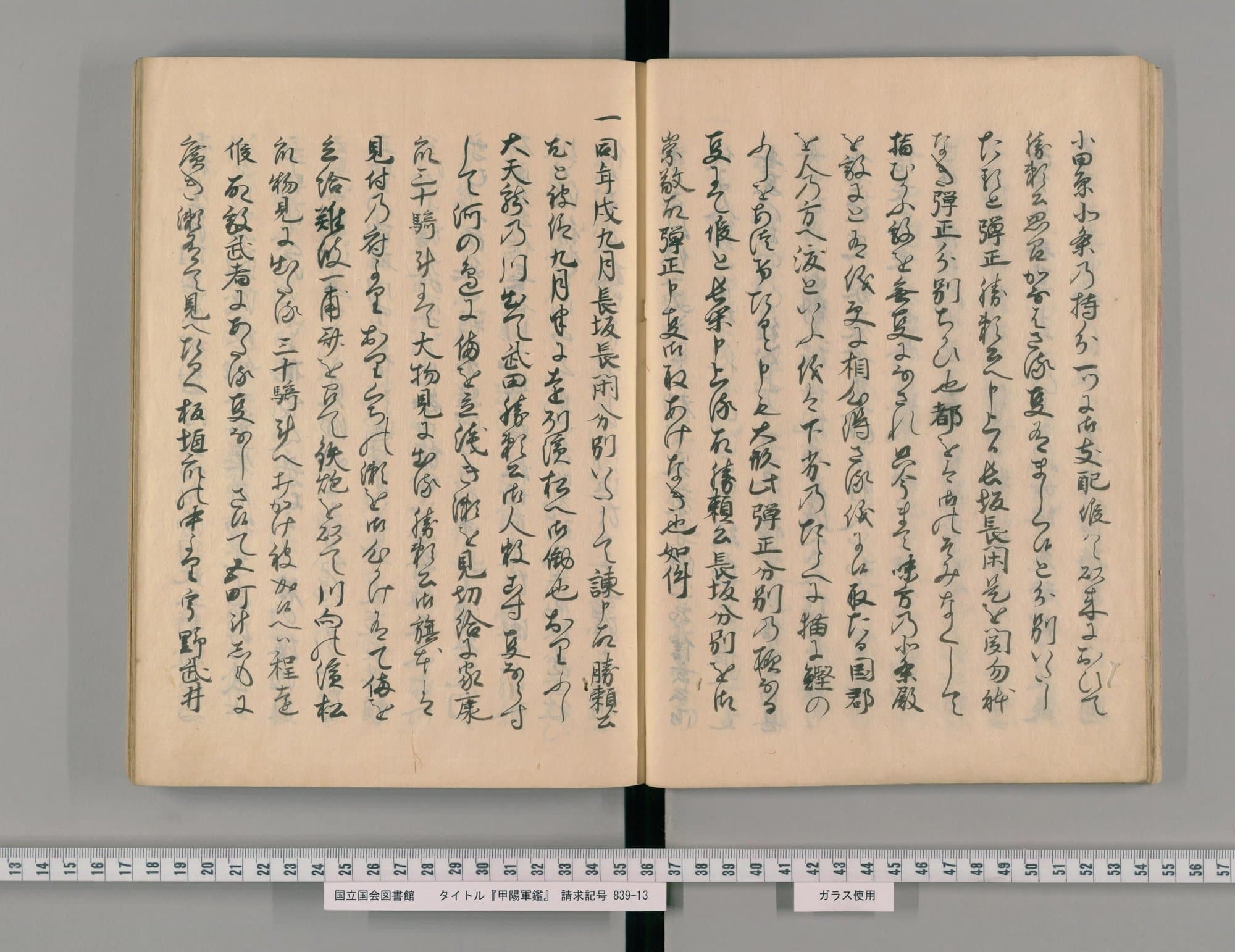 『甲陽軍鑑』写本コマ24の見開き。薄茶の紙に、太い筆のくずし字が1ページ10行ほど並ぶ