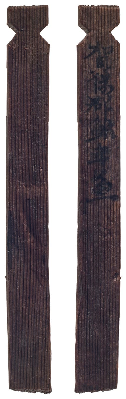 奈良時代の木簡。黒ずんだ細長い2枚の板の写真で、右の面の上半分に墨の字